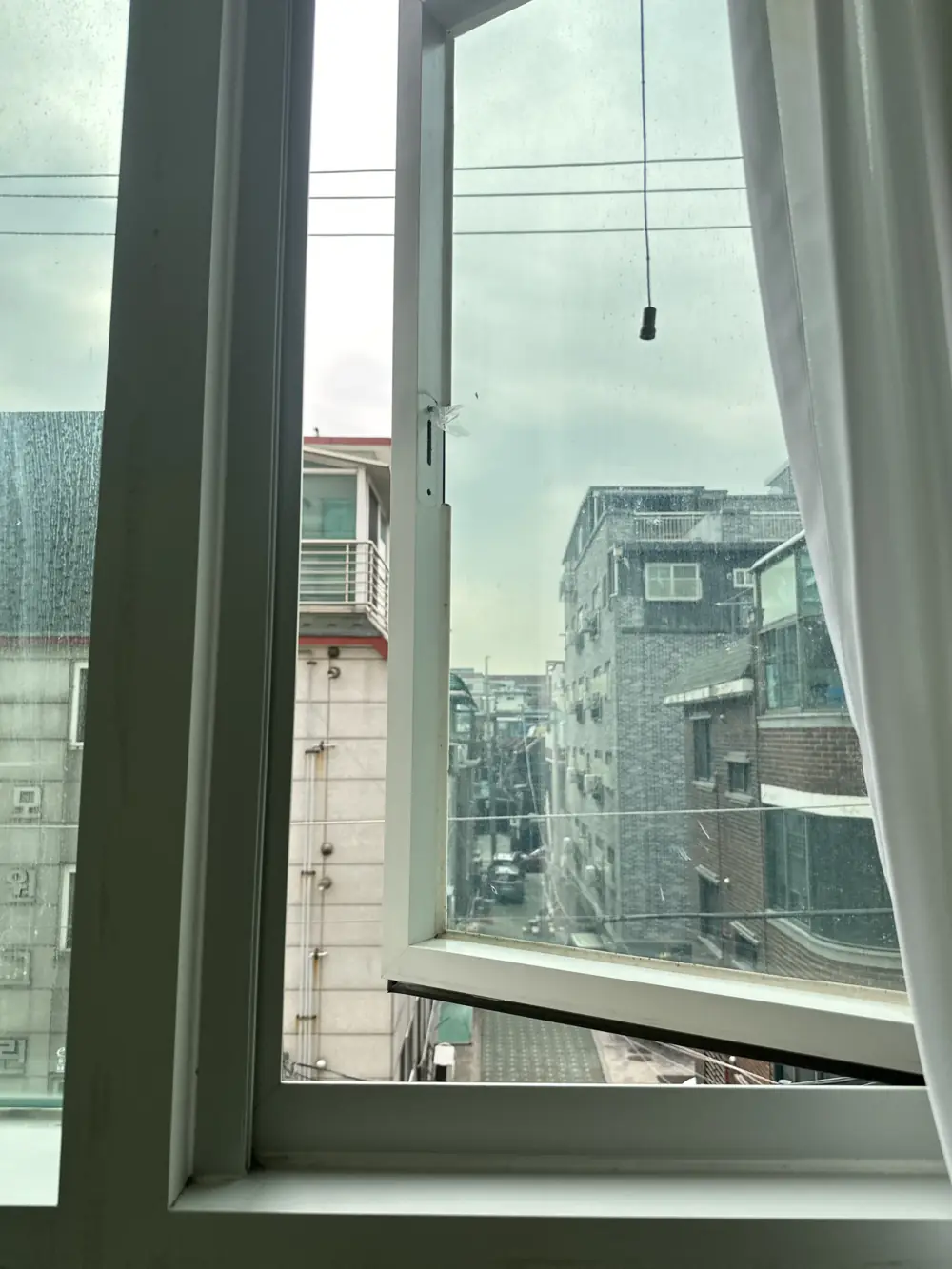 손잡이가 떨어져 나가 창이 비스듬히 열린 창문 설치 이전 모습, 골목 풍경