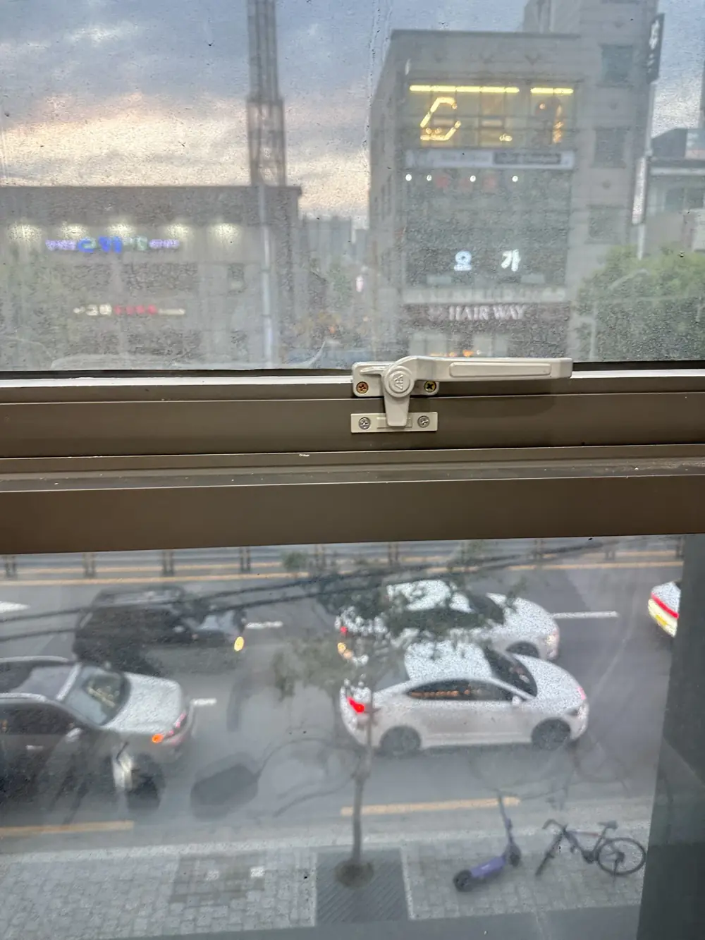 흰색 레버형 창문 손잡이와 걸림판으로 교체한 이후 모습, 도로가 보이는 창틀